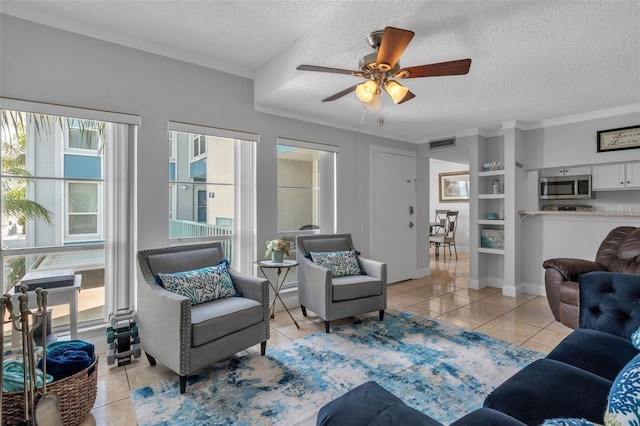 337 Rex Pl Unit E, Madeira Beach, FL 33708 - living area featuring a textured ceiling, light tile patterned flooring, a ceiling fan, ornamental molding, and baseboards