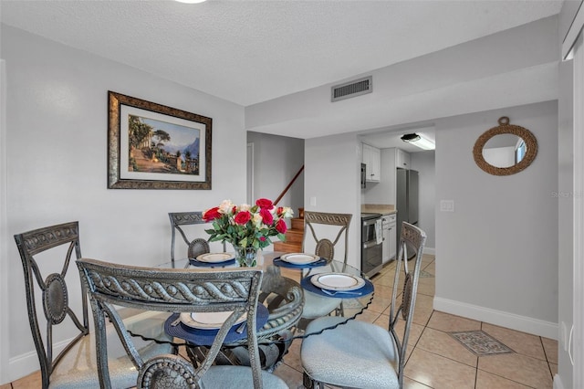 337 Rex Pl Unit E, Madeira Beach, FL 33708 - dining area with baseboards, light tile patterned flooring, and a textured ceiling