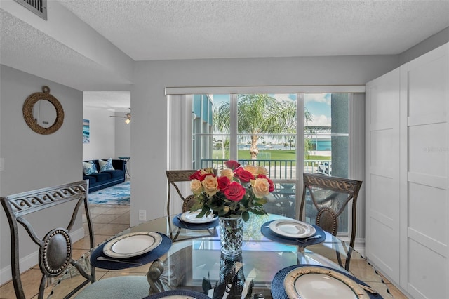 337 Rex Pl Unit E, Madeira Beach, FL 33708 - tiled dining area with a textured ceiling, a water view, and a ceiling fan