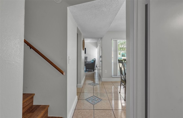 337 Rex Pl Unit E, Madeira Beach, FL 33708 - corridor with light tile patterned floors, a textured ceiling, baseboards, and stairway