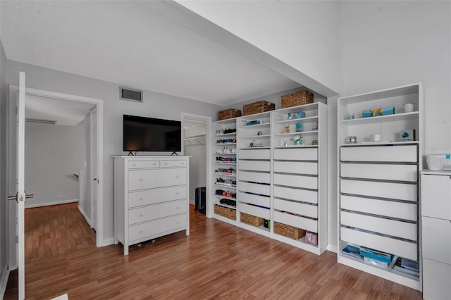 337 Rex Pl Unit E, Madeira Beach, FL 33708 - unfurnished bedroom with wood finished floors, a closet, baseboards, and a spacious closet