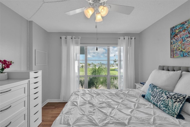 337 Rex Pl Unit E, Madeira Beach, FL 33708 - bedroom featuring dark wood-style flooring, a textured ceiling, and ceiling fan