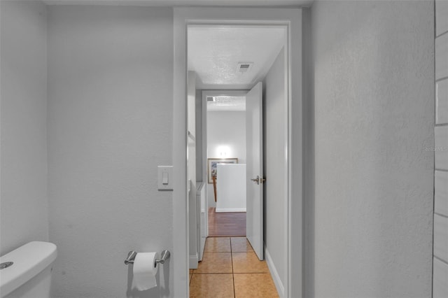 337 Rex Pl Unit E, Madeira Beach, FL 33708 - corridor featuring light tile patterned floors, a textured wall, and baseboards