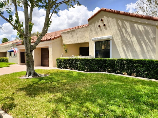 8810 41st St N, Pinellas Park, FL 33782 - mediterranean / spanish home featuring a tile roof, a front yard, stucco siding, and a garage