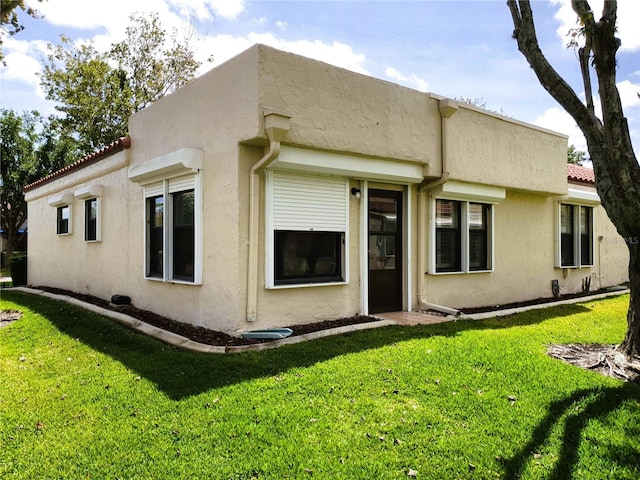 8810 41st St N, Pinellas Park, FL 33782 - back of house with stucco siding, a lawn, and a tiled roof