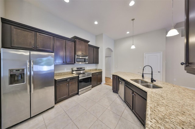 838 Vino Verde Cir, Brandon, FL 33511 - kitchen featuring light tile patterned floors, arched walkways, dark brown cabinets, appliances with stainless steel finishes, and a sink