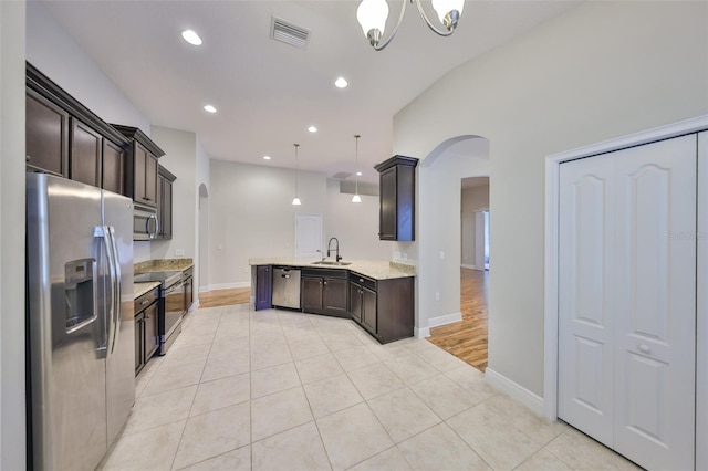 838 Vino Verde Cir, Brandon, FL 33511 - kitchen featuring visible vents, arched walkways, a sink, appliances with stainless steel finishes, and dark brown cabinetry