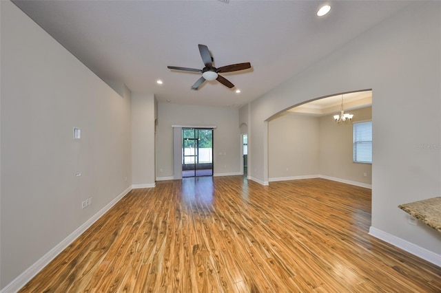 838 Vino Verde Cir, Brandon, FL 33511 - unfurnished living room featuring baseboards, arched walkways, light wood-type flooring, recessed lighting, and ceiling fan with notable chandelier