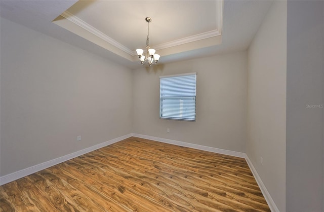 838 Vino Verde Cir, Brandon, FL 33511 - spare room featuring baseboards, an inviting chandelier, ornamental molding, a tray ceiling, and wood finished floors