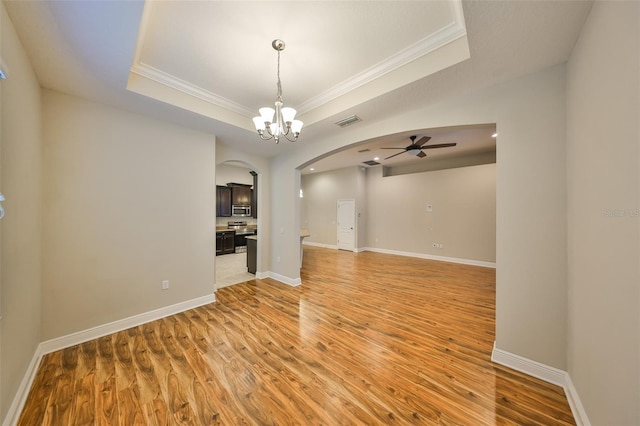 838 Vino Verde Cir, Brandon, FL 33511 - empty room featuring ceiling fan with notable chandelier, arched walkways, ornamental molding, visible vents, and a raised ceiling
