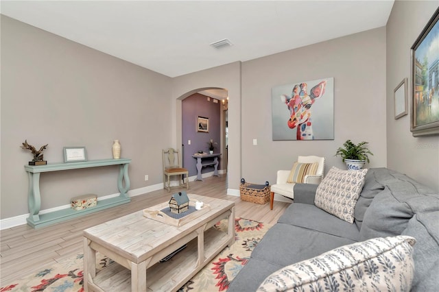 3408 W Bay Ave, Tampa, FL 33611 - living area featuring arched walkways, visible vents, wood finished floors, and baseboards