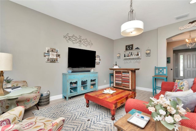3408 W Bay Ave, Tampa, FL 33611 - living area featuring light wood finished floors, arched walkways, visible vents, and baseboards
