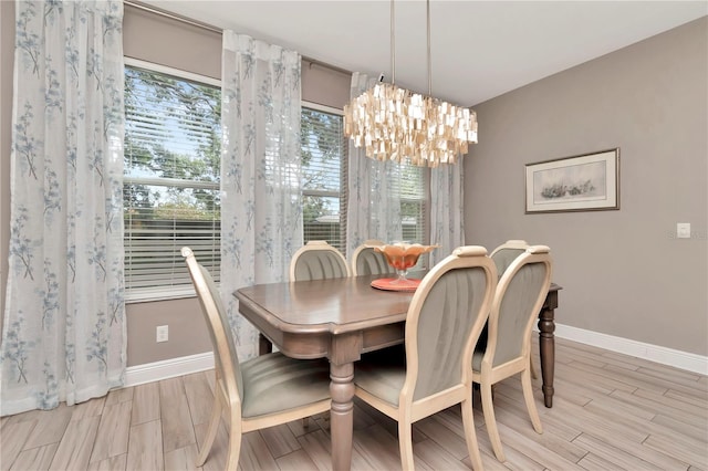 3408 W Bay Ave, Tampa, FL 33611 - dining room featuring light wood-type flooring, a notable chandelier, and baseboards