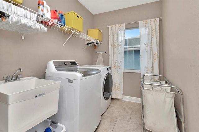 3408 W Bay Ave, Tampa, FL 33611 - clothes washing area featuring a sink, washer and clothes dryer, light tile patterned floors, laundry area, and baseboards