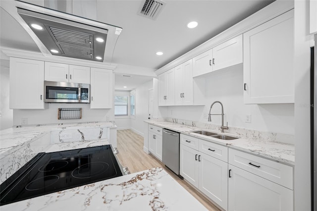 kitchen featuring light stone counters, a sink, white cabinetry, stainless steel appliances, and visible vents
