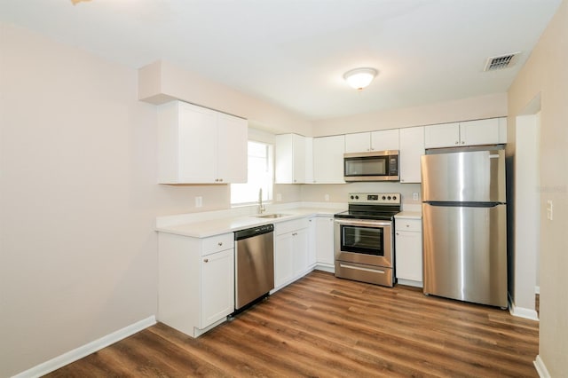 1602 E New Orleans Ave, Tampa, FL 33610 - kitchen with stainless steel appliances, dark wood-style floors, light countertops, and white cabinets