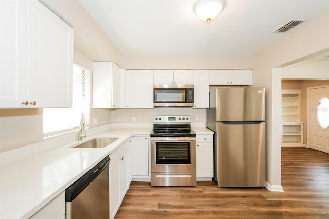 1602 E New Orleans Ave, Tampa, FL 33610 - kitchen with stainless steel appliances, white cabinetry, light countertops, and wood finished floors