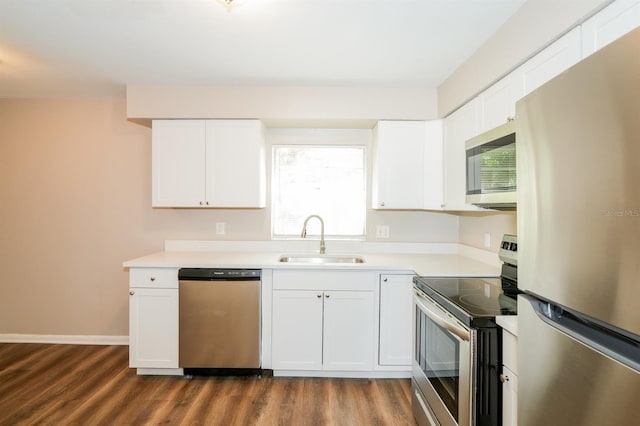 1602 E New Orleans Ave, Tampa, FL 33610 - kitchen featuring appliances with stainless steel finishes, dark wood finished floors, light countertops, and white cabinets