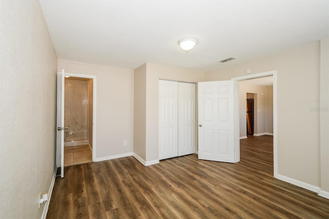 1602 E New Orleans Ave, Tampa, FL 33610 - unfurnished bedroom with dark wood-type flooring, a closet, and ensuite bath