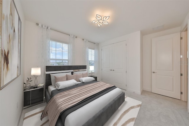 bedroom featuring baseboards, a closet, and light colored carpet