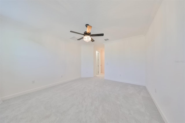 unfurnished room featuring visible vents, baseboards, ornamental molding, a ceiling fan, and light carpet