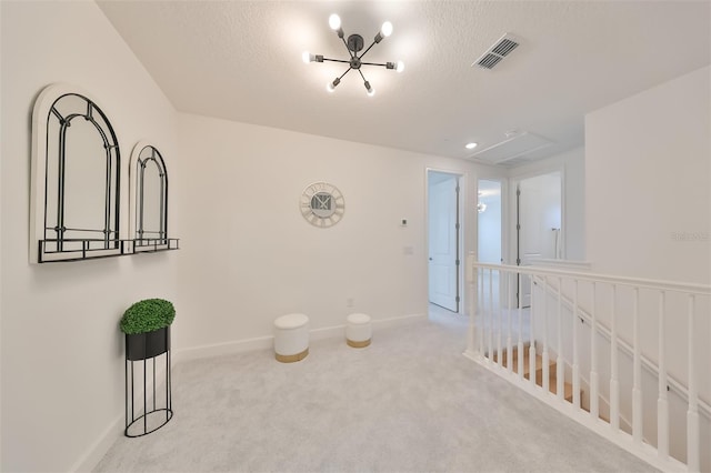 corridor featuring carpet flooring, an upstairs landing, visible vents, a textured ceiling, and baseboards