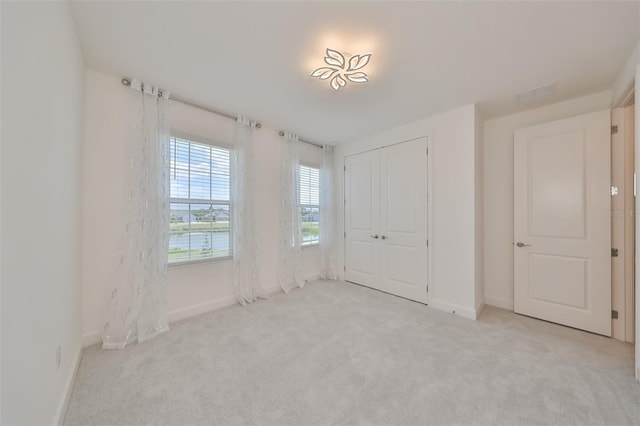 unfurnished bedroom with baseboards, a closet, and carpet flooring