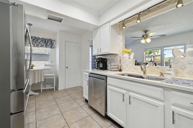 kitchen with tasteful backsplash, a sink, light countertops, appliances with stainless steel finishes, and visible vents