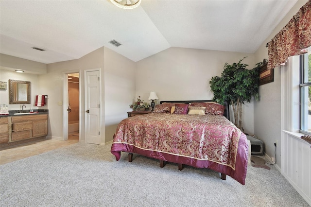 bedroom with vaulted ceiling, light carpet, a sink, and visible vents