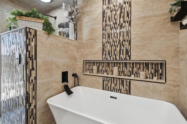 full bathroom featuring a freestanding bath and tile walls