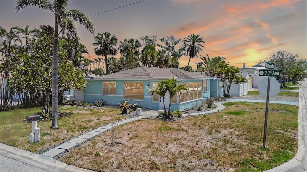 512 79th Ave, St Pete Beach, FL 33706 - view of front of property with a front yard and stucco siding