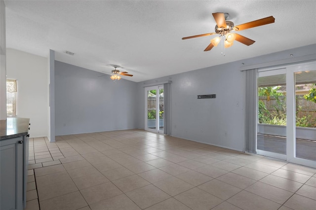 5814 Silver Moon Ave, Tampa, FL 33625 - spare room with ceiling fan, vaulted ceiling, light tile patterned floors, and a textured ceiling