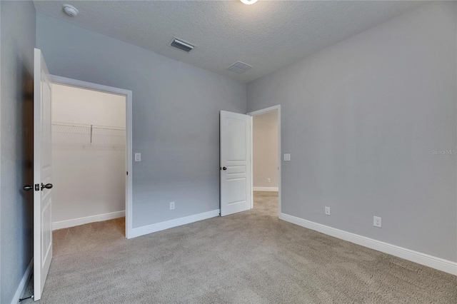 6611 Current Dr, Apollo Beach, FL 33572 - unfurnished bedroom with carpet floors, a spacious closet, a textured ceiling, baseboards, and a closet