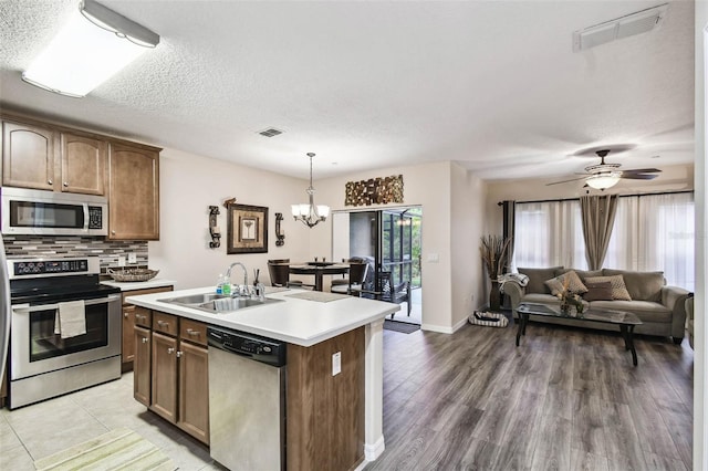 kitchen with decorative backsplash, a sink, stainless steel appliances, and visible vents