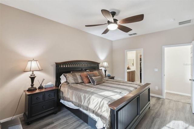 bedroom with baseboards, visible vents, and wood finished floors