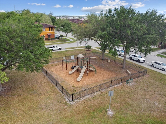 community jungle gym featuring a yard and fence
