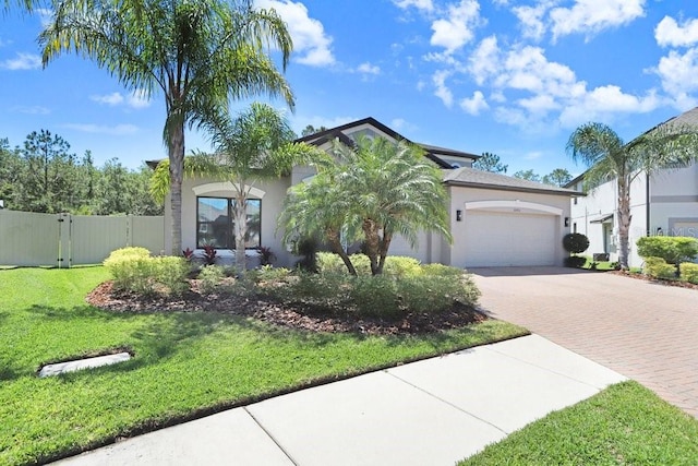 10703 Morning Dew Way, Tampa, FL 33647 - view of front of home with fence, decorative driveway, an attached garage, a front yard, and stucco siding