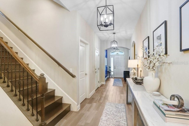10703 Morning Dew Way, Tampa, FL 33647 - foyer with stairs, light wood-type flooring, baseboards, a chandelier, and arched walkways