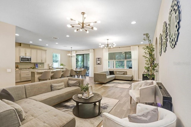 10703 Morning Dew Way, Tampa, FL 33647 - living area with visible vents, an inviting chandelier, recessed lighting, and light wood-type flooring