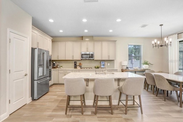 10703 Morning Dew Way, Tampa, FL 33647 - kitchen featuring a breakfast bar area, a chandelier, backsplash, and stainless steel appliances