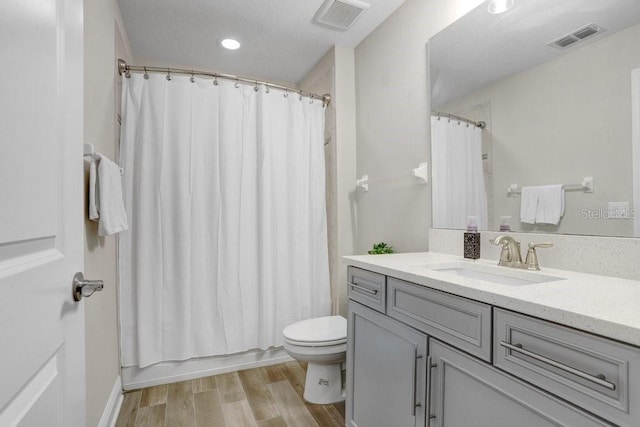 10703 Morning Dew Way, Tampa, FL 33647 - bathroom with visible vents, toilet, vanity, and wood finished floors