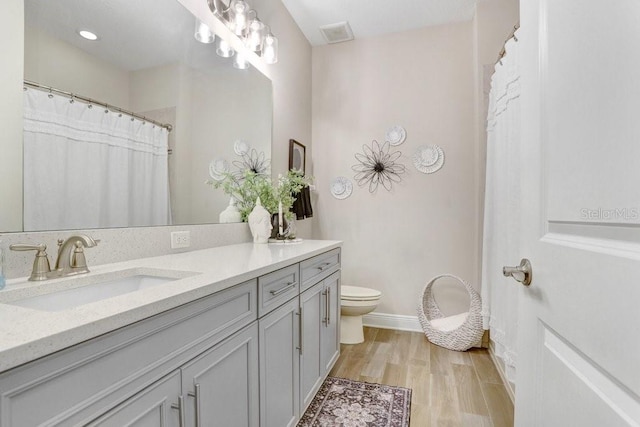 10703 Morning Dew Way, Tampa, FL 33647 - bathroom featuring baseboards, wood finished floors, toilet, and vanity