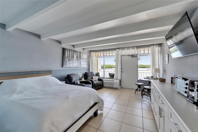 bedroom featuring beamed ceiling, a textured wall, and light tile patterned floors