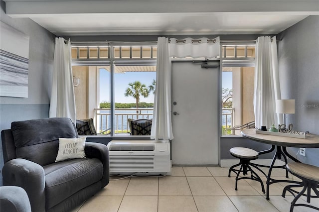 living area featuring a wall mounted air conditioner, tile patterned flooring, and a water view