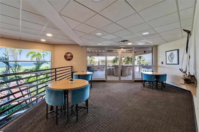 interior space featuring a wealth of natural light, a paneled ceiling, a water view, and visible vents