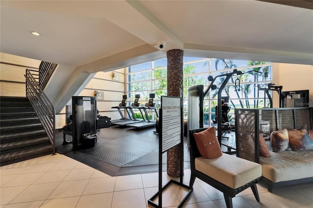 exercise room with tile patterned flooring and vaulted ceiling