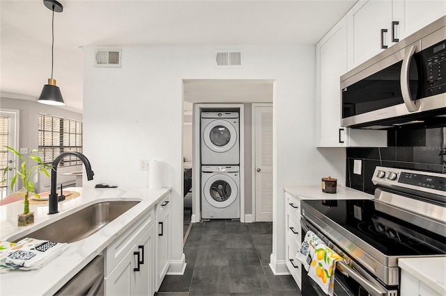 1000 W Horatio St Unit 207, Tampa, FL 33606 - kitchen featuring stacked washer and dryer, visible vents, a sink, and appliances with stainless steel finishes