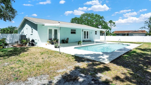 6035 19th St NE, Saint Petersburg, FL 33703 - back of property with french doors, stucco siding, and a patio