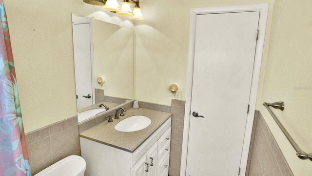 6035 19th St NE, Saint Petersburg, FL 33703 - bathroom with tile walls, vanity, wainscoting, and toilet