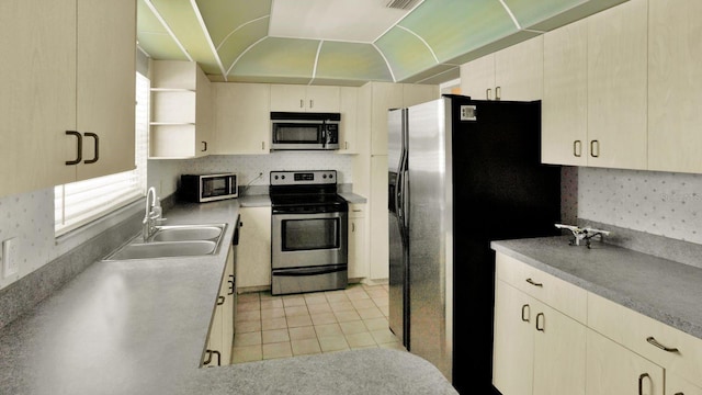 6035 19th St NE, Saint Petersburg, FL 33703 - kitchen featuring stainless steel appliances, a sink, light tile patterned flooring, and light countertops
